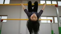 Seorang murid berlatih gimnastik di Shanghai Yangpu Youth Amateur Athletic School (Reuters)