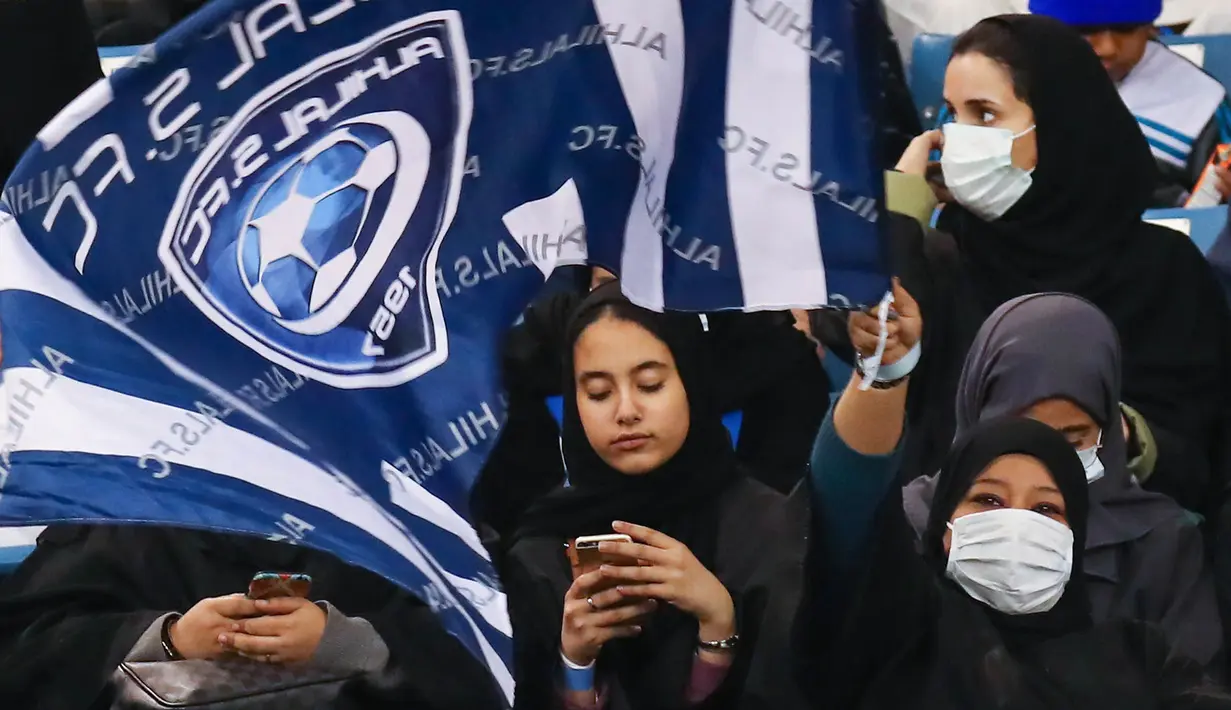 Sejumlah pendukung wanita Al-Hilal menonton timnya saat bertanding di Liga Saudi Pro, Riyadh (13/1). Wanita yang menggemari sepak bola sebelumnya hanya diizinkan menonton pertandingan melalui televisi di rumah. (AFP Photo/Ali Al-Arifi)