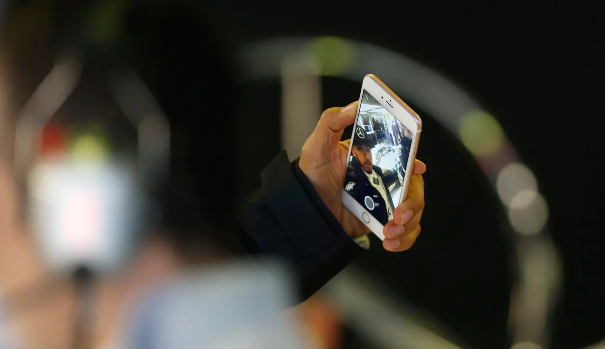 Lewis Hamilton berselfie saat bersiap untuk memulai latihan kedua Formula One Grand Prix di Melbourne, Australia, (17/03/16). Lewis Hamilton memiliki 2 juta followers di media sosial Instagram dengan 1887 foto. (REUTERS/Brandon Malone)