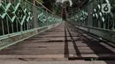 Kondisi jembatan yang berlubang di Jembatan Wiratman, Srengseng Sawah, Jakarta, Sabtu (12/3/2022). Jembatan tersebut mengalami kerusakan pada papan pijak yang mulai berlubang serta besi yang berkarat dan dapat membahayakan warga yang melintas. (Liputan6.com/Herman Zakharia)