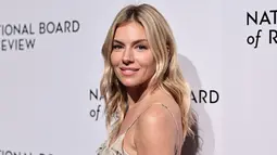 Sienna Miller berpose saat tiba untuk acara National Board of Review Awards Gala di Cipriani 42nd Street di New York City pada 8 Januari 2023. Miller mengenakan rambut pirang mudanya yang dibelah di tengah dan mengalir ke bawah dalam gelombang lembut. (Jamie McCarthy/Getty Images for National Board of Review/AFP)
