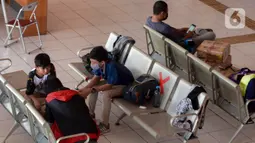 Sejumlah calon pemudik menanti kedatangan bus di Terminal Kampung Rambutan, Jakarta, Rabu (22/4/2020). Terminal Kampung Rambutan masih melayani penumpang menjelang pelarangan mudik Lebaran 2020 guna memutus mata rantai penyebaran COVID-19 pada Jumat 24 April mendatang. (merdeka.com/Imam Buhori)