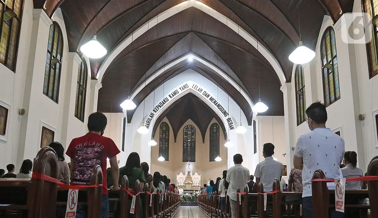 Jemaat umat kristiani melaksanakan Malam Misa Natal di Gereja Katedral Santo Petrus Bandung, Jawa Barat, Kamis (24/12/2020). Pelaksanaan Malam Misa Natal di tengah pandemi Covid-19 tersebut dilakukan dengan menerapkan protokol kesehatan ketat. (Liputan6.com/Herman Zakharia)