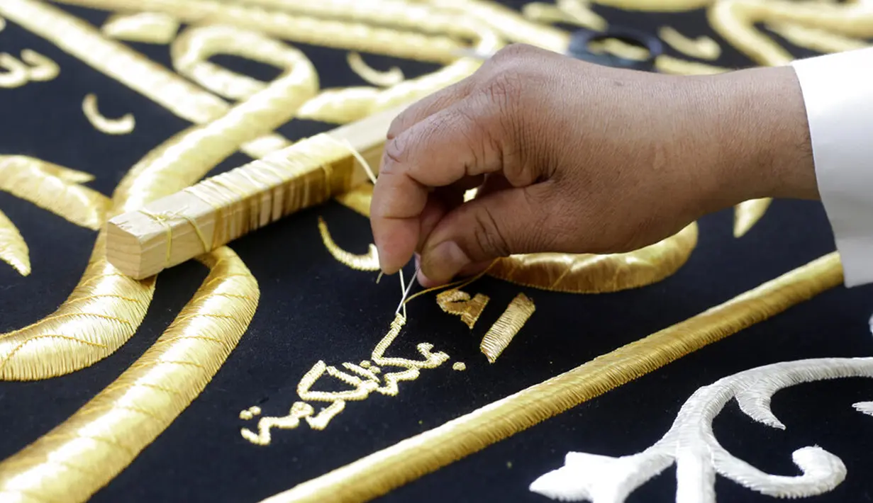 Pekerja menyulam kaligrafi Islam menggunakan benang berlapis emas pada tahap akhir pembuatan Kiswah Kabah di pabrik Kiswah di Mekah, Arab Saudi, Rabu (14/7/2021). Kiswah yang menutupi Kabah diganti setiap tahun untuk umrah atau haji. (AP Photo/Amr Nabil)