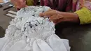 Teknik merajut menjadi penentu keindahan sasirangan. Dengan menggunakan jarum dan benang, kain dijelujur mengikuti garis-garis hasil lukisan dan disisit atau ditarik sehingga nampak hasil kain mengkerut (Liputan6.com/Novi Nadya)