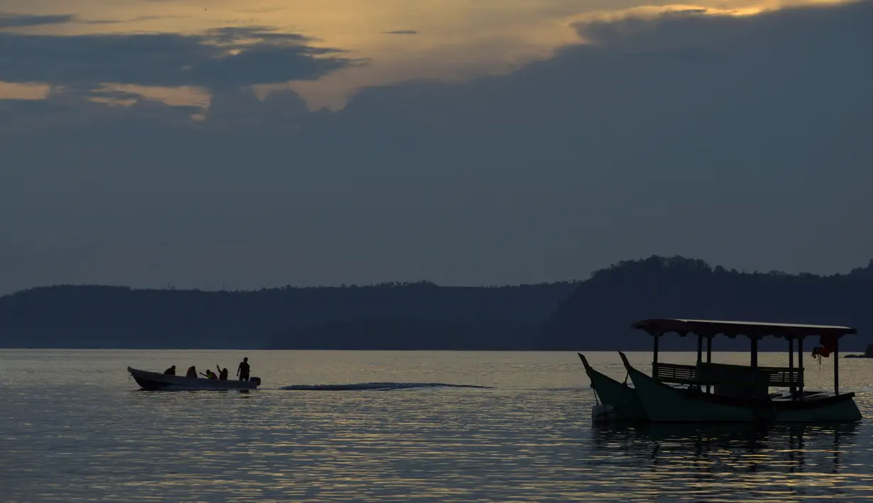 Orang-orang menggunakan kapal menyeberangi air di Iboih, taman pantai dan pariwisata yang populer di seberang teluk dari Sabang di pulau Weh, provinsi Aceh (6/10/2019). (AFP Photo/Chaideer Mahyuddin)