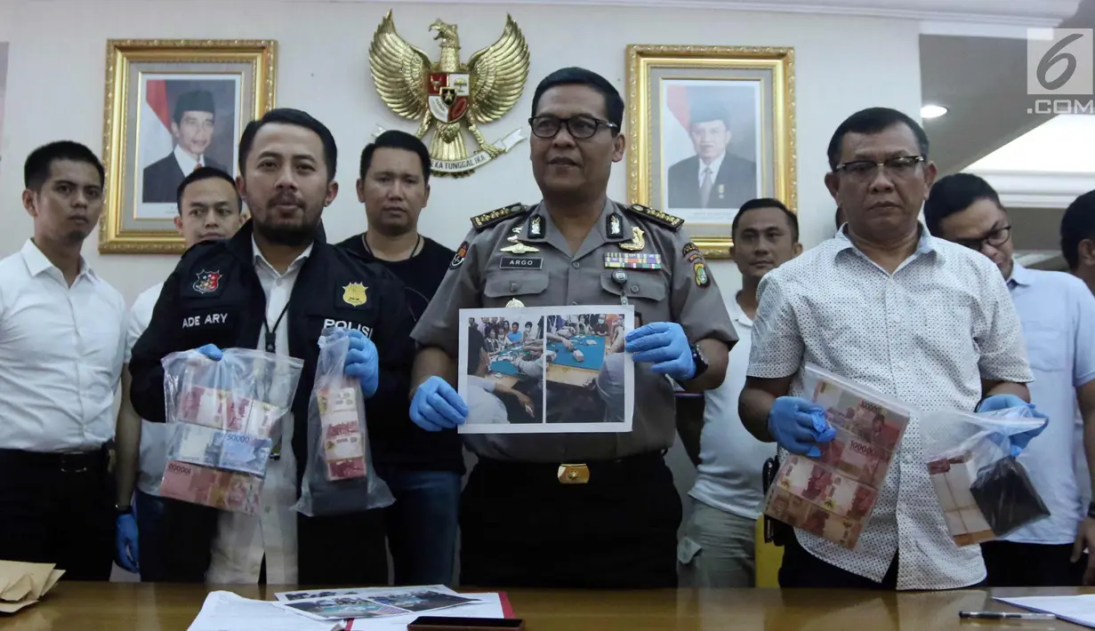 Kabid Humas Polda Metro Jaya Kombes Pol Argo Yuwono (tengah) menunjukkan barang bukti saat rilis perkara tindak pidana perjudian (pai kyu dan koprok) di Polda Metro Jaya, Jakarta, Rabu (14/3). (Liputan6.com/Arya Manggala)