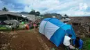 Warga memasang tenda  hunian sementara penyintas  gempa di Desa Mangunkerta, Cianjur, Jumat (23/12/2022). Lebih dari sebulan sejak musibah gempa bumi 5,2 SR sejumlah warga masih tinggal di pengungsian dan hunian sementara dengan bantuan kebutuhan hidup dari para donatur. (merdeka.com/Arie Basuki)