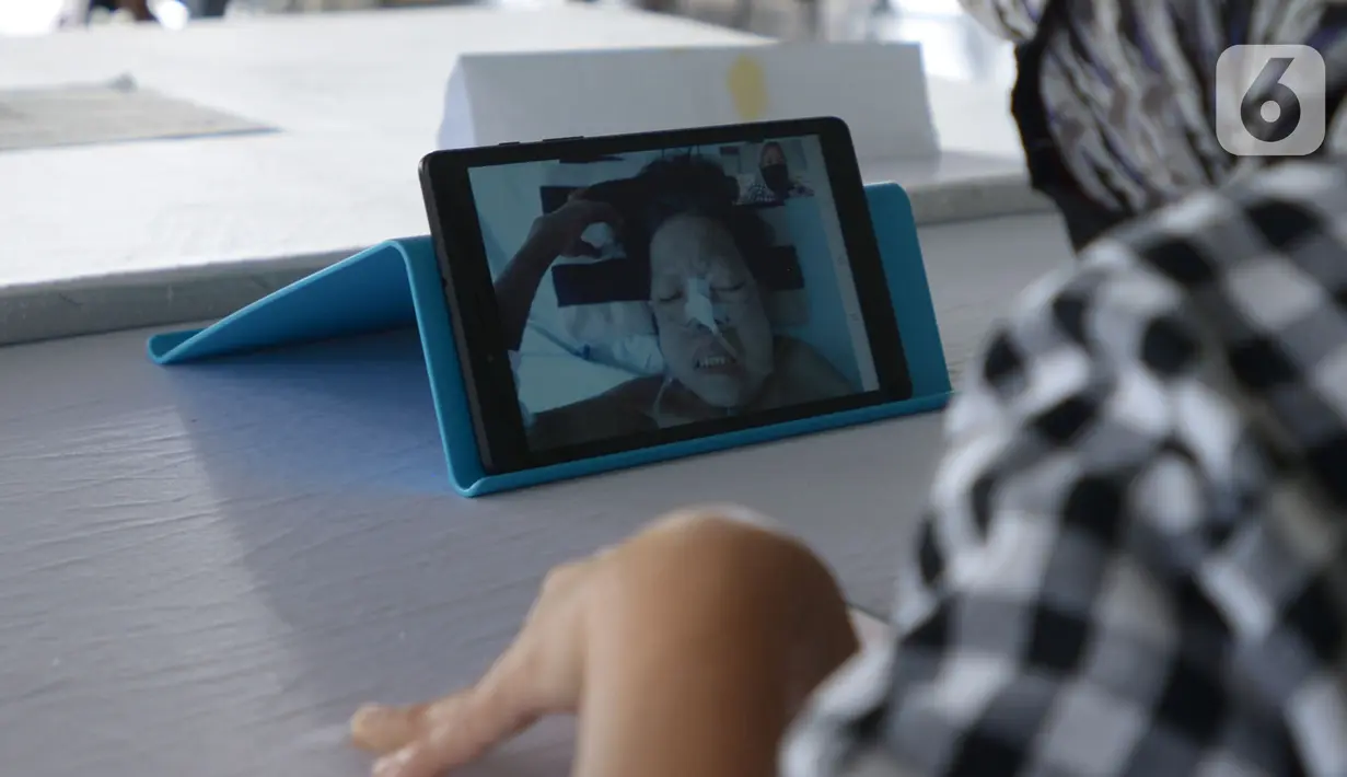Keluarga melakukan video call dengan pasien di RSCM, Jakarta, Selasa (26/5/2020). Fasilitas itu bernama "Pojok Sahabat",Karena tidak bisa jenguk langsung untuk bertegur sapa dengan keluarga yang dirawat dalam ruangan khusus memalui video call. (merdeka.com/Imam Buhori)