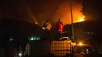 Orang-orang menunggu di atas truk air saat kebakaran hutan berkobar di Gunung Pirque, El Hoyo, wilayah Patagonia provinsi Chubut, Argentina pada 7 Januari 2026. Ribuan hektar hutan di Gunung Pirque, El Hoyo, wilayah Patagonia provinsi Chubut, Argentina, hancur akibat kebakaran yang terjadi sejak 6 Januari 2026. (Martin LEVICOY/AFP)