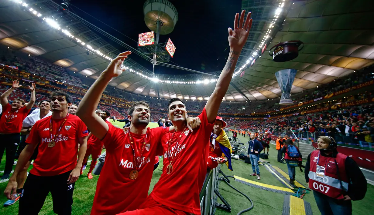 Coke dan Jose Antonio Reyes menyapa pendukung Sevilla di tengah perayaan gelar Liga Europa 2015 di Stadion Narodowy, Polandia, Kamis (28/5/2015). Sevilla memecahkan rekor meraih trofi Liga Europa terbanyak, yakni empat gelar. (Reuters/Kai Pfaffenbach)