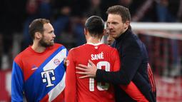 Pelatih Julian Nagelsmann (kanan) merayakan dengan gelandang Bayern Munchen Leroy Sane setelah babak 16 besar Liga Champions UEFA, pertandingan leg kedua melawan Paris Saint-Germain FC di Munich, Jerman selatan, pada 8 Maret 2023. CEO Bayern Munchen yakni Oliver Kahn mengatakan bahwa keputusan klub mengganti Julian Nagelsmann dengan Thomas Tuchel sebagai pelatih ada alasannya. (FRANCK FIFE/AFP)