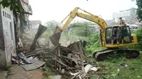 Petugas Satpol PP Kota Bandung menurunkan alat berat untuk meratakan bangunan di atas lahan yang akan dijadikan proyek rumah deret. (Liputan6.com/Huyogo Simbolon)
