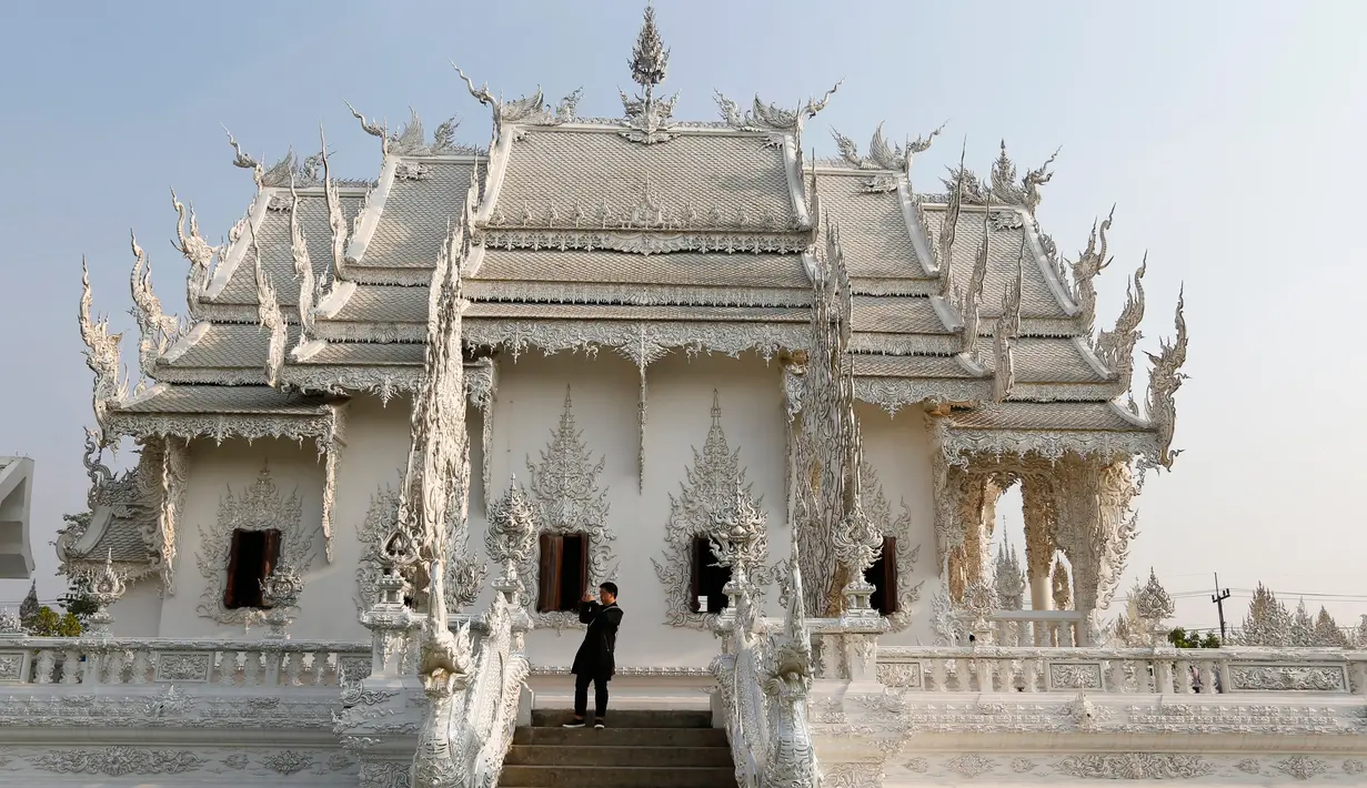 Turis saat melakukan tur di Wat Rong Khun atau kuil putih di Provinsi Chiang Mai, Thailand, Jumat (4/3). Kuil Putih dirancang oleh seniman visual Thai Chalermchai Kositpipat. (REUTERS / Jorge Silva)