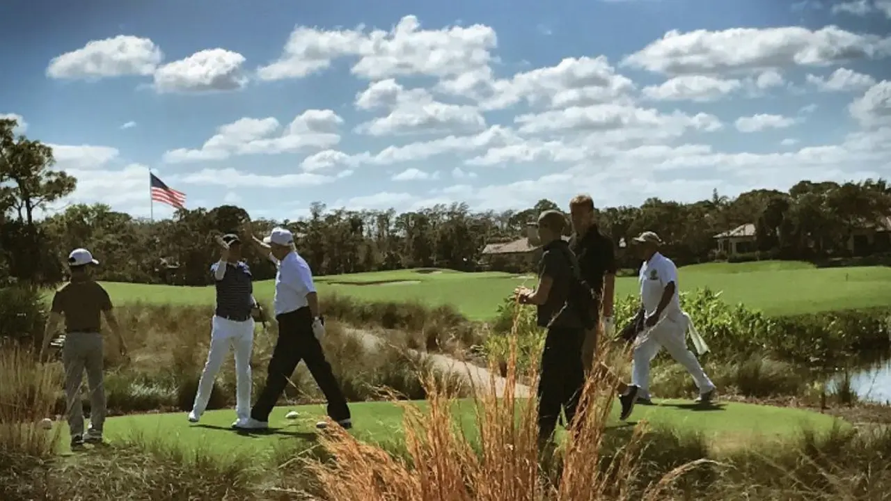 Donald Trump (bertopi putih dan berkaos putih) tengah bermain golf bersama dengan PM Jepang Shinzo Abe