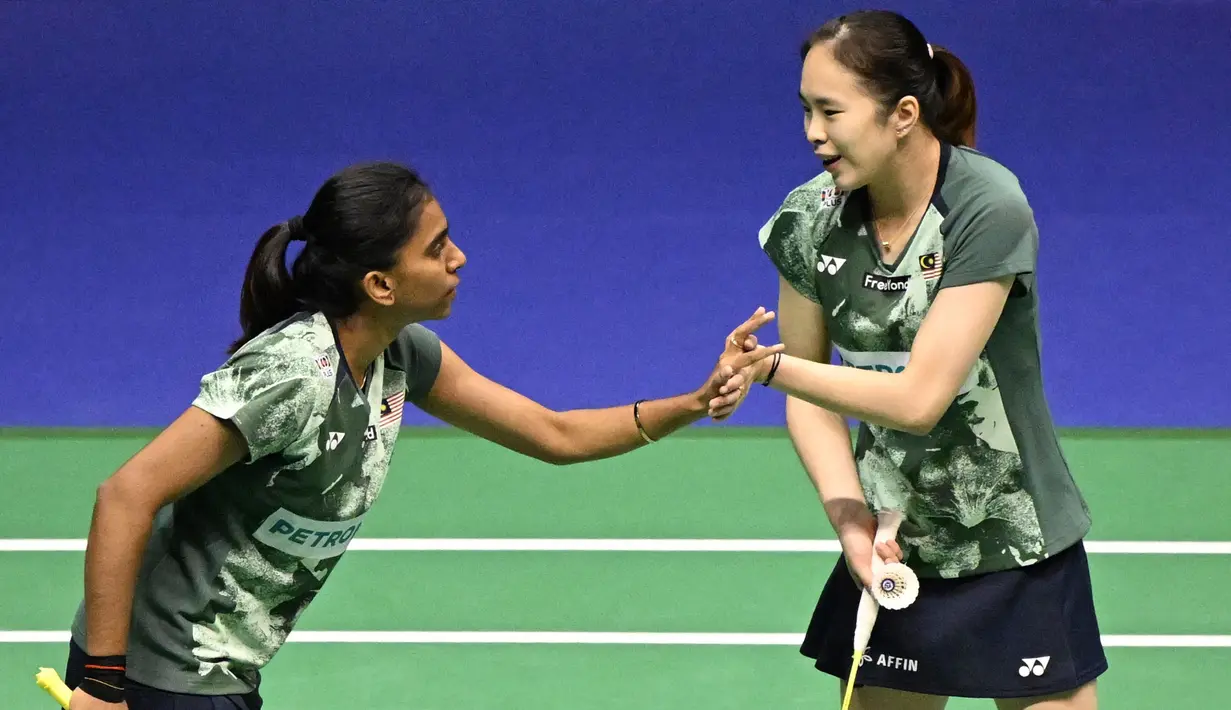 Ganda putri Malaysia, Pearly Tan (kanan) dan Thinaah Muralitharan saling menyemangati saat menghadapi wakil Indonesia, Apriyani Rahayu/Siti Fadia Silva Ramadhanti pada laga final ganda putri Hong Kong Open 2023 di Hong Kong Coliseum, Minggu (17/9/2023) siang WIB. (AFP/Peter Parks)