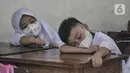 Murid kelas 1 tertidur saat Masa Pengenalan Lingkungan Sekolah (MPLS) di Sekolah Dasar (SD) Negeri Jati 06 Pagi, Pulogadung, Jakarta Timur, Senin (11/7/2022). PTM 100 persen tetap disiplin menerapkan protokol kesehatan guna mencegah penyebaran Covid-19 di lingkungan sekolah. (merdeka.com/Iqbal S. Nugroho)