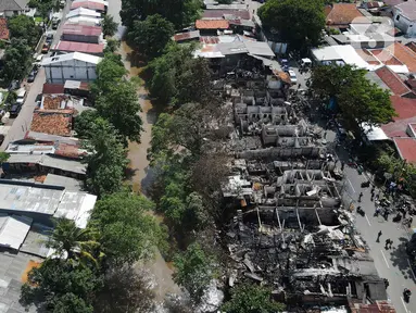 Foto udara lokasi kebakaran pemukiman di kawasan Manggarai, Jakarta, Minggu (18/12/2022). Kebakaran tersebut menghanguskan sekitar 50 rumah semi permanen yang ada di bantaran sungai Ciliwung. (Liputan6.com/Herman Zakharia)