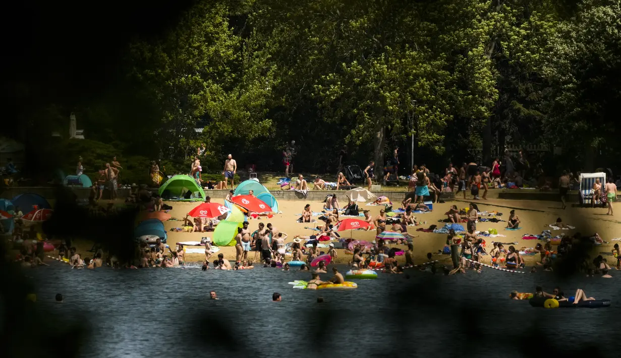 Orang-orang menikmati hari musim panas di danau Orankesee di Berlin, Jerman, Minggu (19/6/2022). Orang-orang berbondong-bondong ke taman dan kolam renang di seluruh Eropa Barat untuk sedikit mendinginkan tubuh mereka dari gelombang panas awal. (AP Photo/Markus Schreiber)