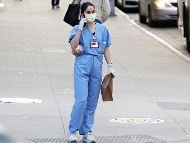 Pekerja medis tiba untuk shiftnya di RS NewYork-Presbyterian/Weill Cornell Medical Center selama pandemi COVID-19 di New York City (21/4/2020). COVID-19 telah menyebar ke sebagian besar negara di dunia, lebih dari 175.000 jiwa dengan infeksi lebih dari 2,5 juta orang. (Cindy Ord/Getty Images/AFP)