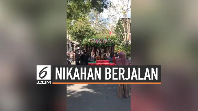 Viral sebuah video memperlihatkan sebuah pernikahan berjalan di jalan raya. Ternyata ini bukan pernikahan sungguhan, melainkan sebuah karnaval budaya.
