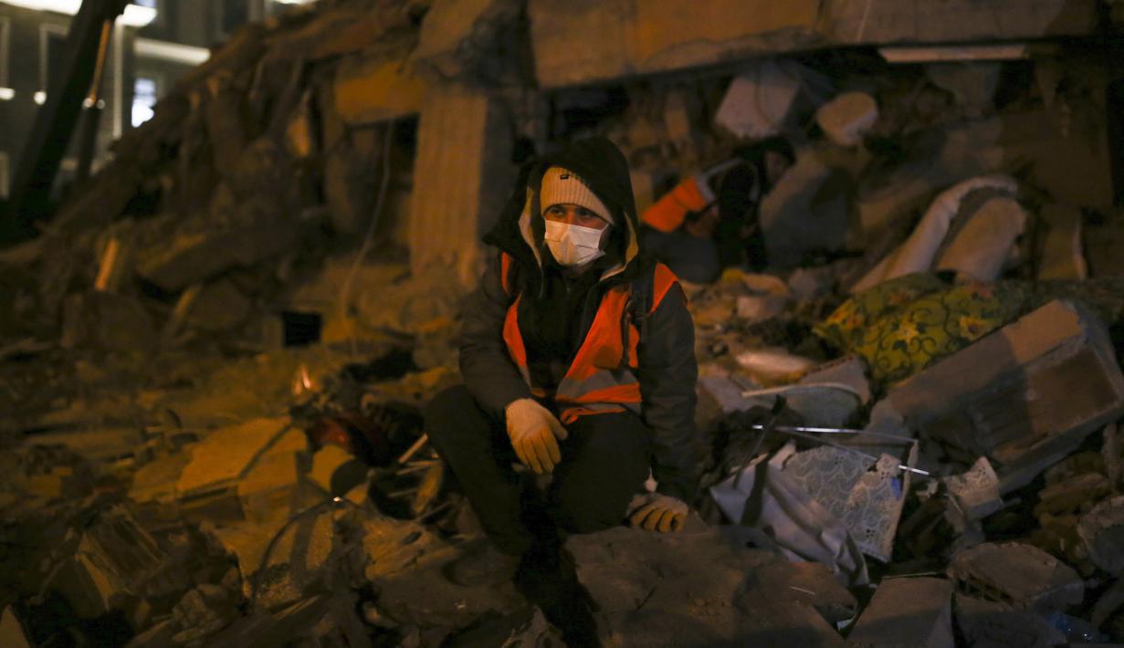 Seorang pria duduk di depan bangunan yang hancur, di Adiyaman, tenggara Turki, Rabu, 8 Februari 2023. Para ahli mengatakan jendela kelangsungan hidup bagi mereka yang terjebak di bawah reruntuhan bangunan yang runtuh makin sulit.  (AP Photo/Emrah Gurel)