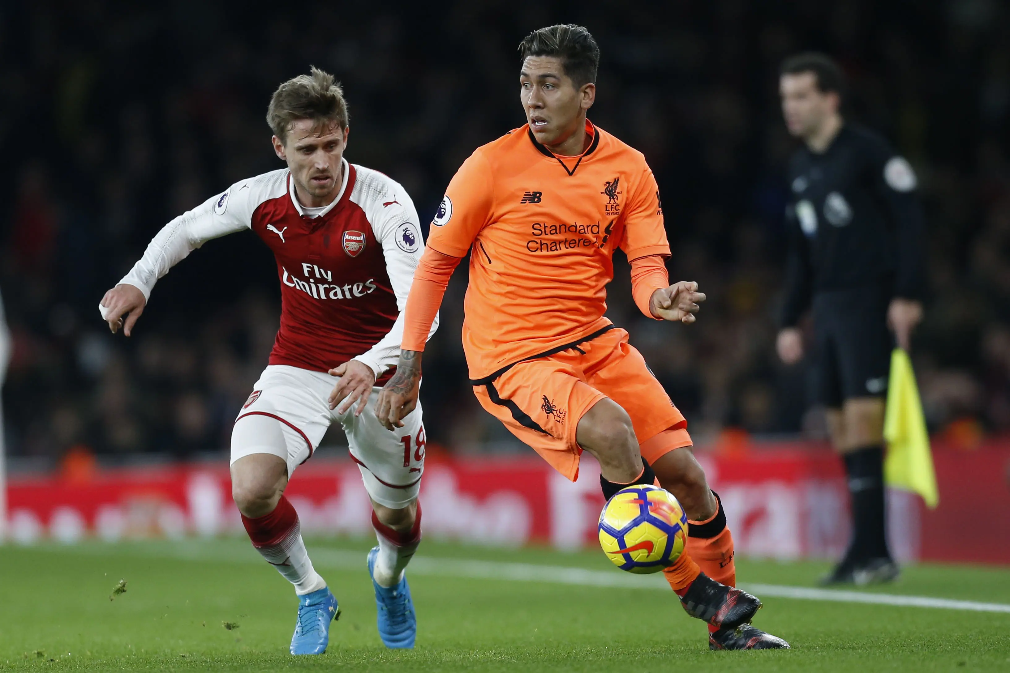 Penyerang Liverpool, Roberto Firmino coba menguasai bola dari kawalan pemain Arsenal. (AFP/Ian Kington)