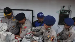 Anggota polisi memindahkan serpihan berupa tangga darurat dan tabung gas yang diduga milik pesawat AirAsia QZ8501 di Pelabuhan Kumai, Pangkalan Bun, Kalteng, Kamis (1/1/2015). (Liputan6.com/Herman Zakharia)