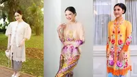 Erina Gudono tampil anggun dalam balutan kebaya encim berwarna oranye dengan bordiran bunga warna-warni dan kain batik Betawi berwarna sky blue. [Instagram/erinagudono]