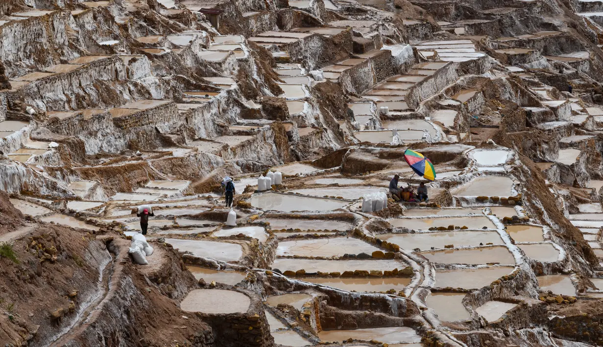 Pekerja beraktivitas di tambak garam di Maras, Peru, 29 April 2019. Tambak garam ini sudah digunakan sejak zaman pra-Inca. (Pablo PORCIUNCULA BRUNE/AFP)