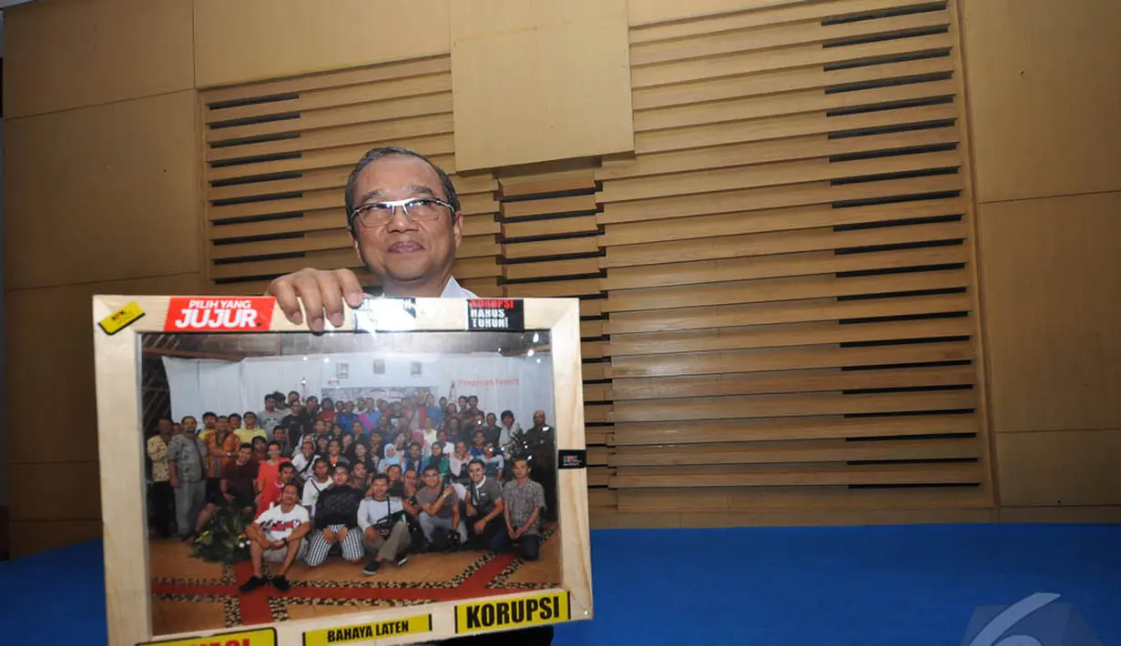 Wakil Ketua KPK, Busyro Muqoddas mendapat kenang-kenangan berupa foto dari awak media, Jakarta, Selasa (16/12/2014). (Liputan6.com/Miftahul Hayat)
