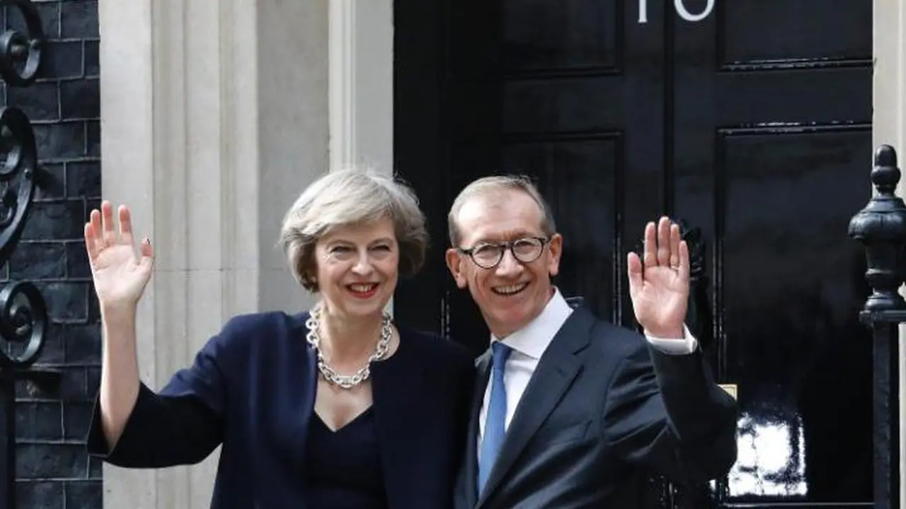 PM Theresa May dan sang suami, Philip melambaikan tangan di depan Downing Street 10