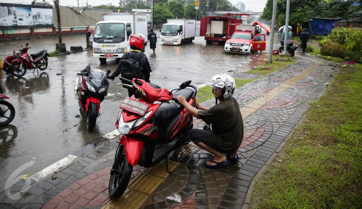 Sejumlah kendaran mengalami mogok usai memaksakan melintas air banjir di jalan Gunung Sahari menuju Ancol, Jakarta, Selasa (21/2). Hujan deras sejak malam tadi, membuat sejumlah wilayah Jakarta tergenang air banjir. (Liputan6.com/Faizal Fanani)