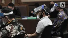 Para terdakwa mengenakan masker dan face shield saat menjalani sidang perdana kasus korupsi PT Asuransi Jiwasraya di Pengadilan Tipikor, Jakarta, Rabu (3/6/2020). Sidang yang menghadirkan enam terdakwa tersebut menerapkan protokol social distancing. (merdeka.com/Iqbal S. Nugroho)