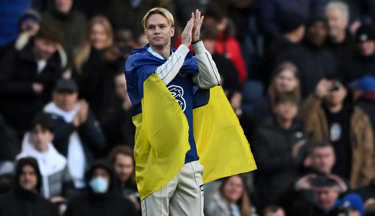 Rekrutan baru Chelsea, Mykhailo Mudryk memperkenalkan dirinya sambil membawa bendera Ukraina saat jeda babak pertama laga lanjutan Liga Inggris 2022/2023 melawan Crystal Palace di Stamford Bridge, London, 15 Januari 2023. Mudryk dibeli Chelsea dari Shakhtar Donetsk dengan harga 70 juta euro pada bursa transfer Januari 2023. (AFP/Ben Stansall)