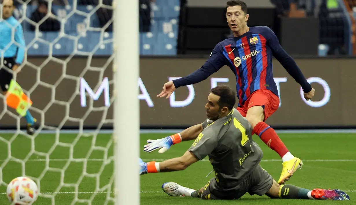 Pada menit ke-40 Barcelona akhinya unggul 1-0 lewat gol Robert Lewandowski. Gol dicetak lewat tembakan rebound yang sempat diblok bek Real Betis, namun akhirnya jatuh kembali ke kaki Lewandowski yang dengan mudah menaklukkan kiper Betis, Claudio Bravo. Keunggulan satu gol Barcelona bertahan hingga babak pertama usai. (AFP/Giuseppe Cacace)