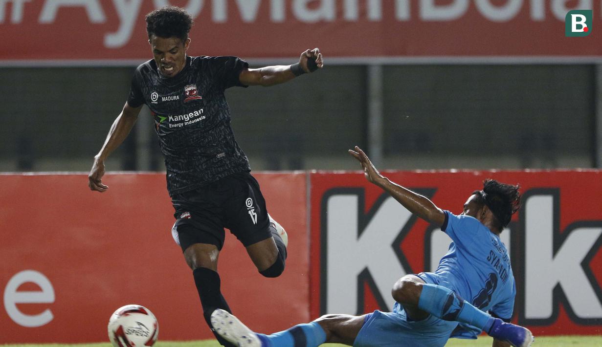 Bek Madura United, Alfin Ismail Tuasalamony (kiri) berusaha melewati gelandang Persela Lamongan, Syahroni dalam laga matchday ke-3 Grup C Piala Menpora 2021 di Stadion Si Jalak Harupat, Bandung, Kamis (1/4/2021). (Bola.com/Ikhwan Yanuar)