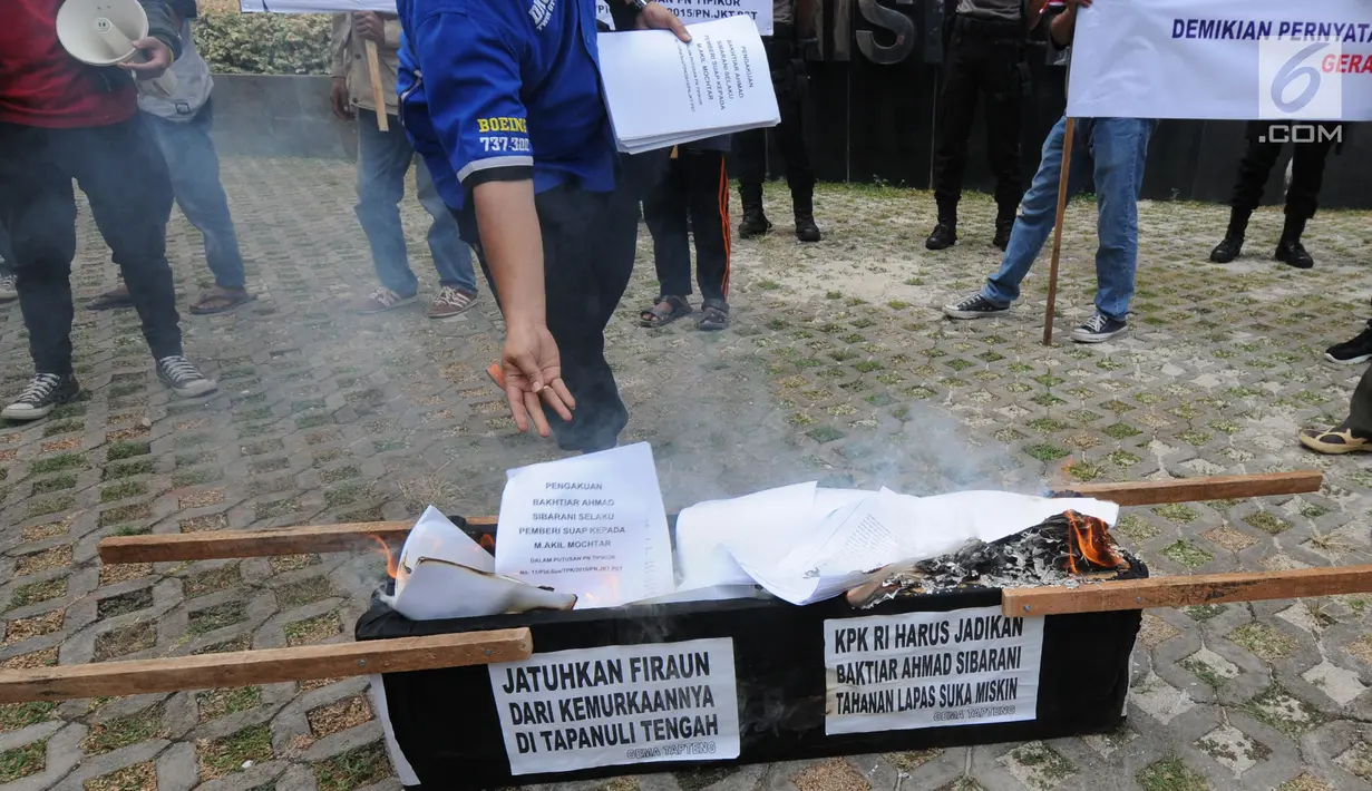 Aktivis Gema Tapteng membakar keranda mayat saat unjukrasa di depan gedung KPK, Jakarta, Rabu (16/5). Mereka mendesak pimpinan KPK segera mengusut sengketa Pilkada Tapanuli Tengah 2011 lalu. (Merdeka.com/Dwi Narwoko)