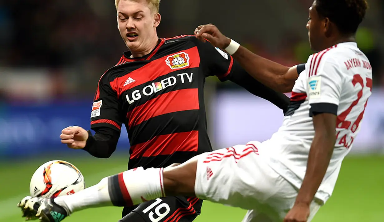 Pemain Bayern Munchen, David Alaba, berusaha menghentikan pergerakan pemain Leverkusen, Julian Brandt. Sementara bagi Leverkusen hasil ini menahan mereka di peringkat lima klasemen sementara. (AFP/Patrik Stollarz)
