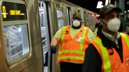 Pekerja otoritas transportasi kota New York bersiap membersihkan gerbong kereta bawah tanah dengan disinfektan di stasiun Coney Island di Brooklyn, Rabu (6/5/2020). Sistem kereta bawah tanah New York dimatikan sementara untuk dibersihkan guna menghentikan penyebaran Covid-19. (AP/Frank Franklin II)