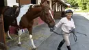 Nicole de Villeneuve (89) bersiap berlatih berkuda selama sesi pelatihan di Arcachon, Prancis (24/4). Seorang wanita cantik dengan mata hijau-biru mengatakan "Obatku adalah kuda, aku lupa segalanya,". (AFP Photo/Georges Gobet)