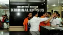 Petugas kepolisian menggiring masuk tersangka kasus pemerasan, Raden Nuh, yang berteriak saat digelar rilis di Mapolda Metro Jaya, Jakarta, Senin (3/11/2014). (Liputan6.com/Andrian M Tunay)