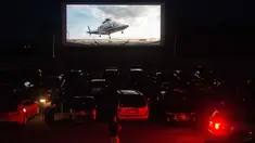 Puluhan mobil terparkir di depan layar bioskop saat pemutaran film drive-in di Family Drive-in di Virginia, 10 Agustus 2018. Menonton film di luar ruangan atau drive-in merupakan bagian penting dalam industri hiburan di Amerika. (AFP PHOTO/Nicholas Kamm)