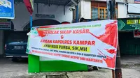 Spanduk berisi desakan Kapolres Kampar dicopot karena dinilai arogan terhadap guru dan kepala desa di Kabupaten Kampar. (Liputan6.com/Istimewa)