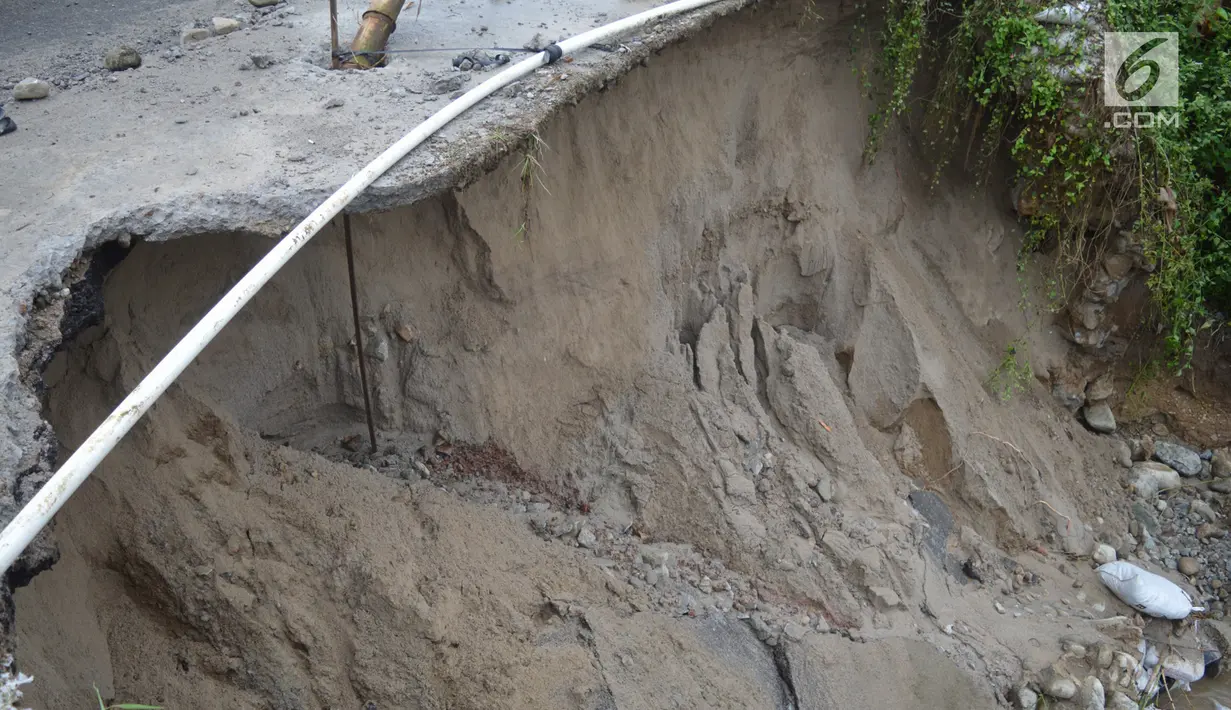 Jalan amblas di kawasan Desa Bondawuna, Kabupaten Bone Bolango, Gorontalo, Selasa (30/4/2019). Hujan yang mengguyur wilayah Kabupaten Bone Bolango mengakibatkan empat desa di Kecamatan Suwawa Selatan, dan Bulango Timur Bone Bolango banjir. (Liputan6.com/Arfandi Ibrahim)