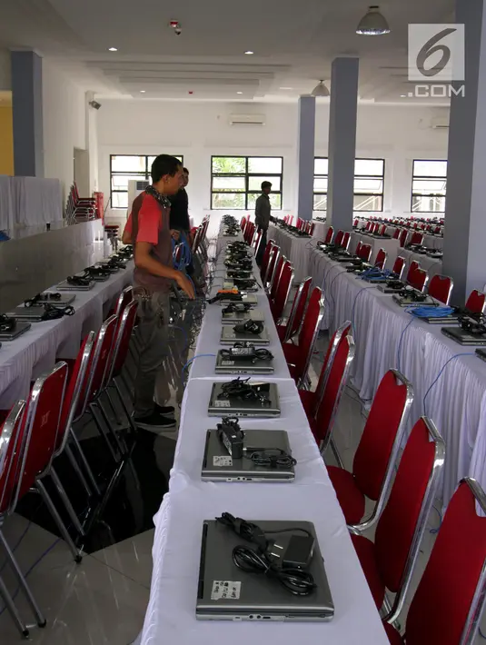 Teknisi menginstal laptop untuk tes calon pegawai negeri sipil (CPNS) di GOR Kelapa Gading, Jakarta Utara, Jumat (26/10). Tempat ini akan menjadi lokasi tes CPNS yang akan dilangsungkan pada Sabtu, 26 Oktober 2018. (Liputan6.com/JohanTallo)