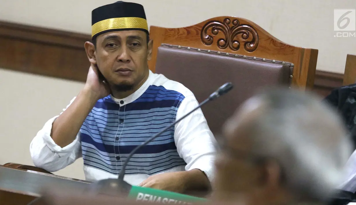 Terdakwa penyebaran berita bohong tentang 7 kontainer berisi surat suara Pemilu 2019 yang telah tercoblos, Bagus Bawana Putra menyimak keterangan Kepala Biro Hukum Sekjen KPU, Sigit Joyowardono saat sidang lanjutan di Pengadilan Negeri Jakarta Pusat, Kamis (11/4). (Liputan6.com/Helmi Fithriansyah)