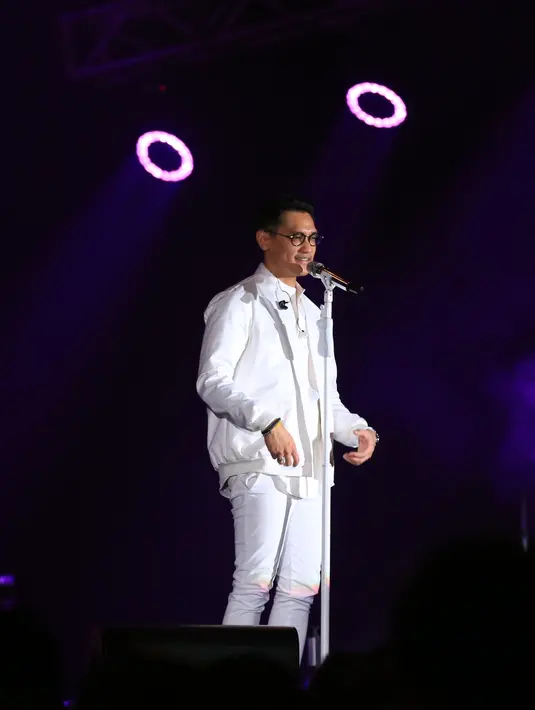 Seketika ruangan menjadi hening ketika Afgan menyanyikan lagu bertajuk Kunci Hati. Pasalnya saat itu ruangan menjadi gelap lantaran lamu hanya fokus pada Afgan yang berbusana putih. (Adrian Putra/Bintang.com)