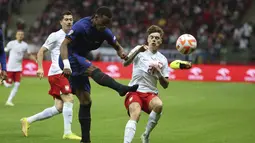 Bek timnas Belanda Jurrien Timber menendang bola dan kehilangan sepatunya saat bertandang ke Polandia dalam lanjutan UEFA Nations League A di Stadion Narodowy, Warsawa pada Jumat (29/09) dini hari WIB. Belanda sukses menundukkan Polandia 2-0 lewat gol yang disumbangkan oleh Cody Gakpo dan Steven Bergwijn. (AP Photo/Michal Dyjuk)