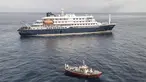 Pemandangan udara sebuah kapal ambulans yang membawa awak yang mengenakan pakaian pelindung bahan berbahaya (hazmat suit) saat mereka mendekati pintu kemudi di sisi kanan kapal pesiar MV Hondius, ketika kapal tersebut berhenti di lepas pelabuhan Praia, ibu kota Tanjung Verde, Selasa 5 Mei 2026. Kapal pesiar MV Hondius saat ini masih tertahan di lepas pantai Praia, Tanjung Verde. (Foto oleh AFP)